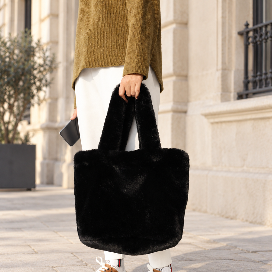 Cabas Teddy Noir tenu en main dans une rue en pierre claire – Brin de Charme