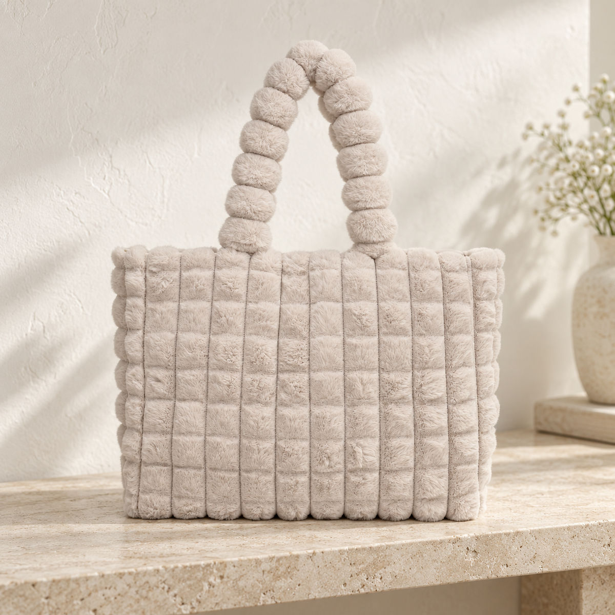 Cabas Peluche Gaufré Beige posé sur une console en pierre – Brin de Charme